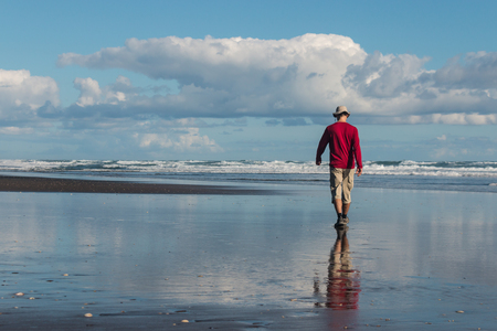 man walking on Karekare beach, New Zealandの写真素材