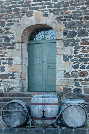 wooden barrels in front of old country houseの写真素材