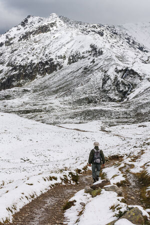 walker on snow covered trackの写真素材
