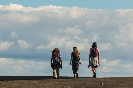 group of people walking across sand dunesの写真素材