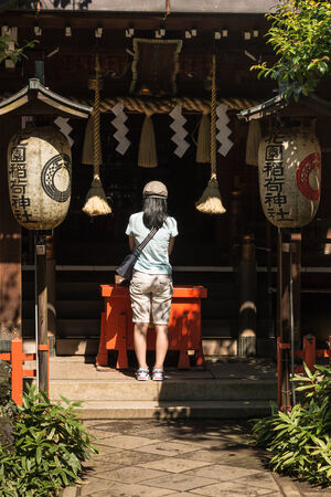 young woman praying at Shinto shrine in Tokyoのeditorial素材