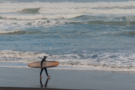 surfer on Muriwai beach in New Zealandの写真素材