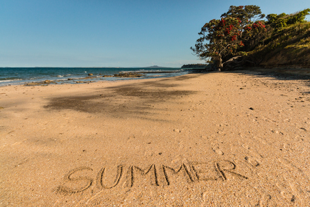 Summer written in sand on New Zealand beachの写真素材