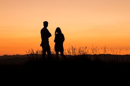 young couple admiring sunsetの写真素材