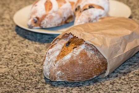 loaf of artisan bread in paper bagの写真素材