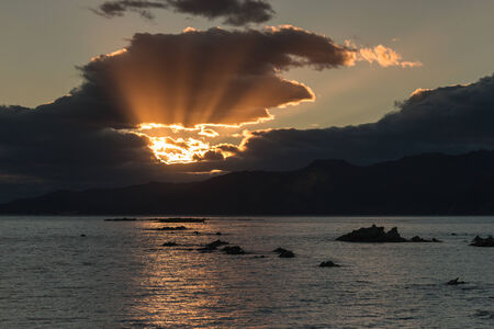 rays of light breaking through clouds at sunsetの写真素材