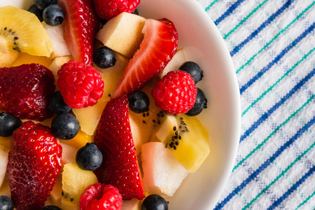 fruit salad in white bowl on table clothの写真素材