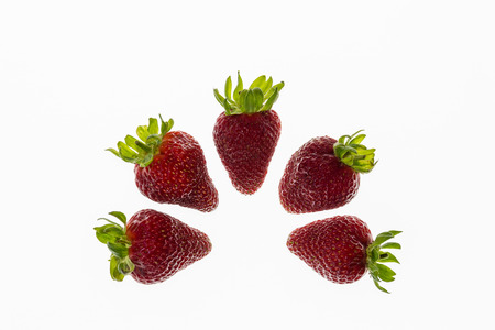 five strawberries arranged in semicircle on white backgroundの写真素材