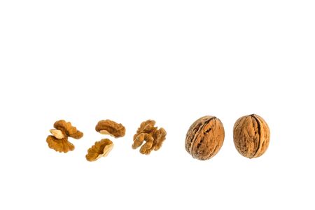 whole walnuts with halved walnut kernels on white background with copy space aboveの写真素材