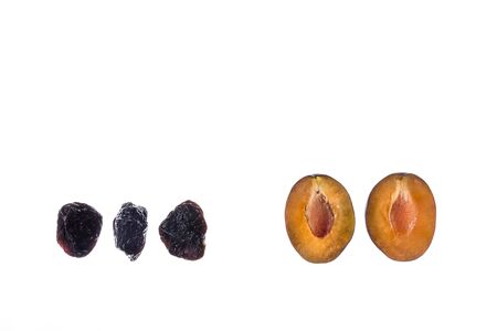 closeup of fresh and dried prune plums on white background with copy space aboveの写真素材