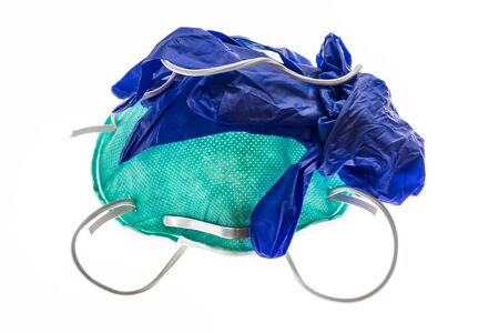 closeup of N95 face mask with blue latex surgical gloves isolated on white backgroundの写真素材