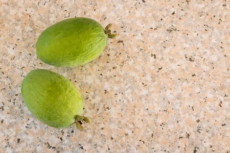closeup of ripe feijoa fruit on marble kitchen bench with copy space on rightの写真素材