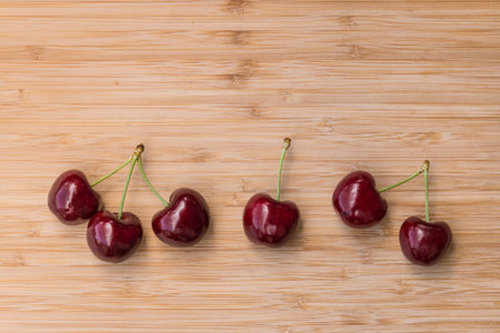 closeup of ripe dark red Stella cherries on bamboo chopping board with copy space aboveの写真素材