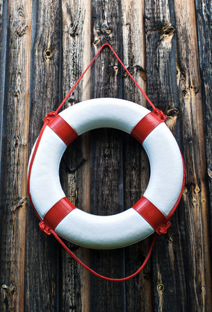 Life buoy against an old wooden wall