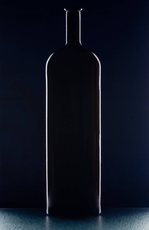 Silhouette of a black bottle on  dark blue backgroundの写真素材