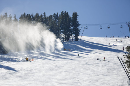 Snowmaking spraying snow on the piste for mountain skiers