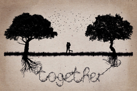 Two trees in front of each other with their roots growing  in shape of the word together and a couple hugging in the middle. Romantic scene. Relationship love and togetherness conceptの写真素材