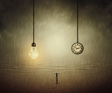 Surreal backround of a man standing with wide opened hands in front of a huge bulb and a clock. Business time and idea conceptの写真素材