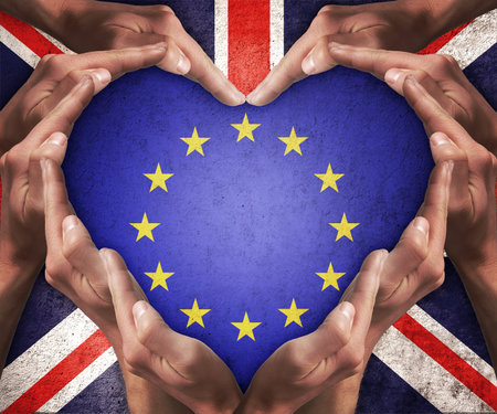 Human hands make heart shape with patterned flag of the European Community inside and the flag of...
