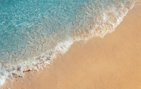 Soft foaming wave of blue sea on a sand beach. Summer vacation background, holiday recreation...