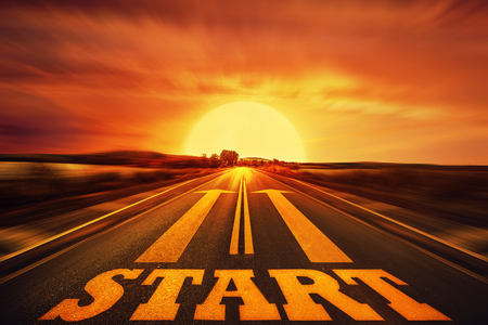 Word Start written on an asphalt road and two arrows as motivation. Long way ahead as a concept of start straight for business.の写真素材