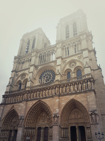 Notre Dame de Paris cathedral facade in a foggy morning. Gorgeous gothic architecture.の写真素材