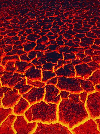 Heat red cracked ground texture burning after eruption volcano. Molten active lava texture background. Armageddon natural disaster or hell concept.の写真素材