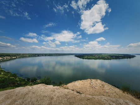 High angle, altitude view to the Nistru river, near Dubasari (Dubossary), Transnistria, Moldova. Idyllic panoramic scene on the peak of a cliff over the water under a rich blue sky.の写真素材