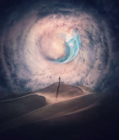 Person silhouette on the top of a dune in a desert looking at the mysterious phenomena in the sky. Surreal scene with a cosmic nebula swirling through the dense clouds. Fantastic and magical landscapeの写真素材