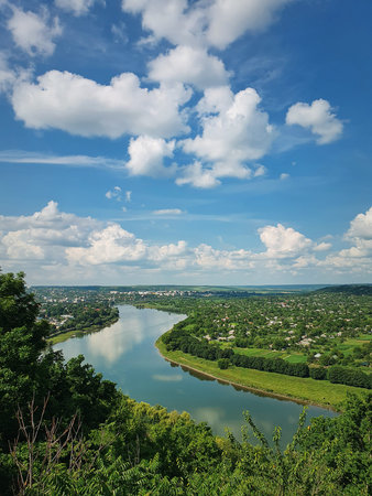 High angle, altitude view to the Nistru river bank, near Soroca city, Moldova. Idyllic vertical scene to the green valley with tiny houses in the filedの写真素材