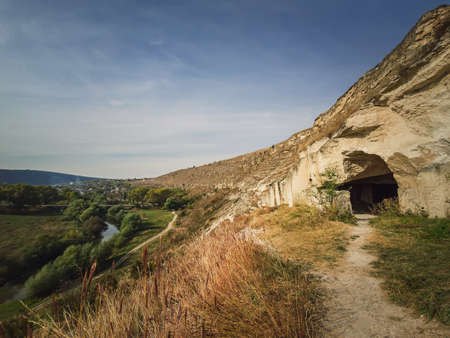 View to the caves of karst limestone hills at Orheiul Vechi, old Orhei complex, near Trebujeni village, Moldova. Autumn season nature landscape alongside Raut riverの写真素材