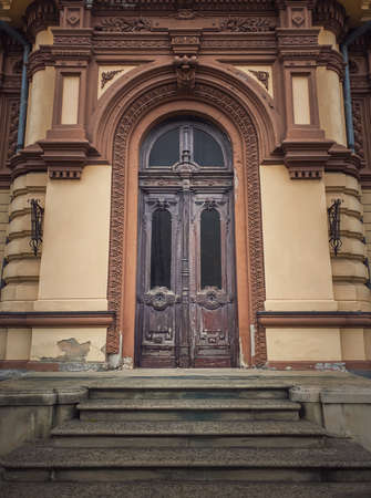 Vintage door and ornate facade details of an old historical building. Outdoors architecture elements. Rustic wooden gate. The main entrance doorwayの写真素材