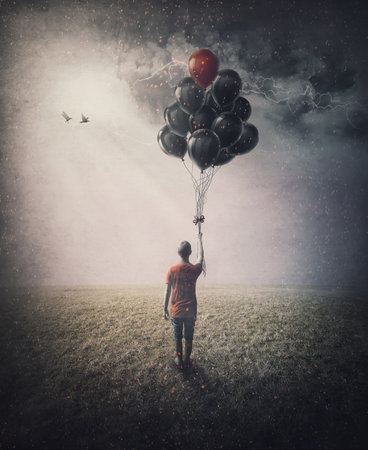 Bizarre scene of a lone person in the field holding a bunch of balloons in his hand in hope of starting flying. Conceptual and inspirational artの写真素材