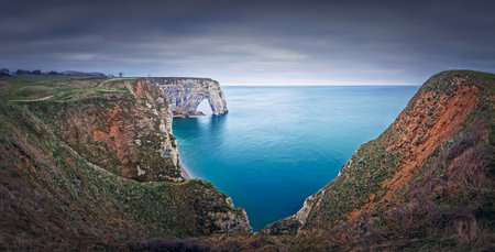 Sightseeing panoramic view to the Porte d'Aval natural arch cliff washed by Atlantic ocean waters at Etretat, Normandy, France. Beautiful coastline scenery with famous Falaise d'Avalの写真素材