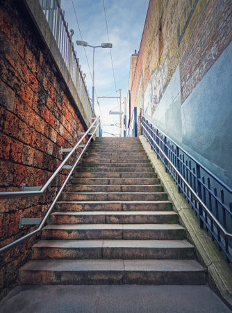 Outdoors staircase behind the buildings walls. Abstract view upstairs, street sceneの写真素材