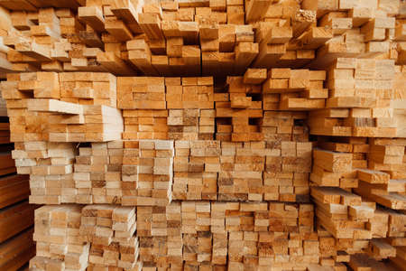 warehouse of wooden boards, background texture of wood harvested for shipment to the factory, finished products of the woodworking industry, many smooth bars of woodの写真素材
