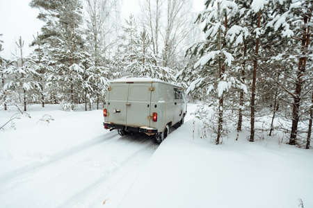 the car got stuck in the winter in the forest, bad weather after a heavy snowfall completely covered the roads, waiting for a tow truck far outside the cityの写真素材