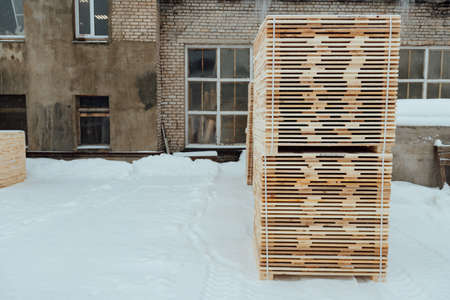warehouse of wooden boards, background texture of wood harvested for shipment to the factory, finished products of the woodworking industry, many smooth bars of woodの写真素材