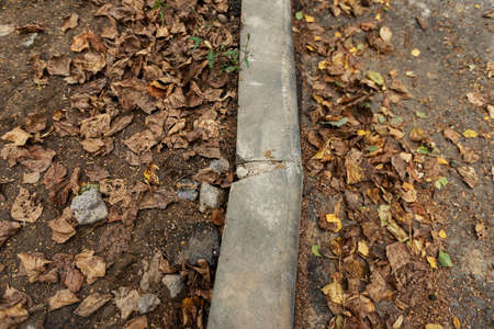 poorly executed road repairs. replacing the old curb stone with a new one. road workingの写真素材