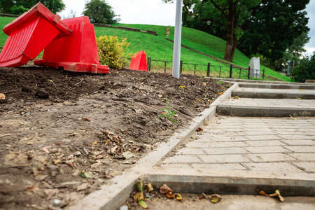 poorly executed road repairs. replacing the old curb stone with a new one. bad quality of a road workの写真素材