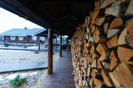 Pile of firewood in a wooden house. A stack of firewood in a wooden house.