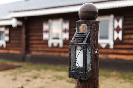 Lantern on the background of a wooden house in the villageの写真素材