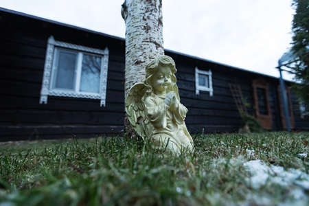 Wooden sculpture in the yard of a country house in winter.の写真素材
