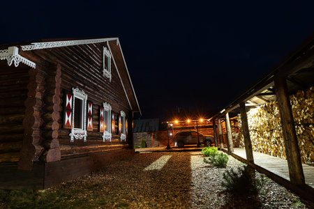 Old wooden house at night in the village. Wooden log house.の写真素材
