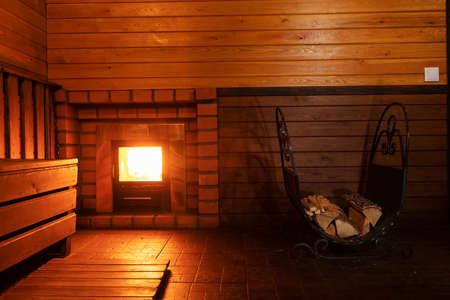 Interior of a sauna with a fireplace in a wooden houseの写真素材