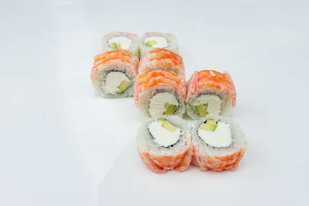 a portion of sushi rolls with sweet and sour sauce is on the white table, a dish of Asian cuisine from rice and seafood for eating in the restaurantの写真素材