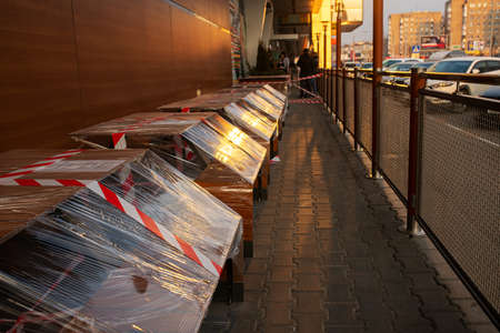 the summer cafe of the fast food restaurant is closed for quarantine during the epidemic, access to visitors is prohibited, and chairs and tables are tied with a warning tapeの写真素材