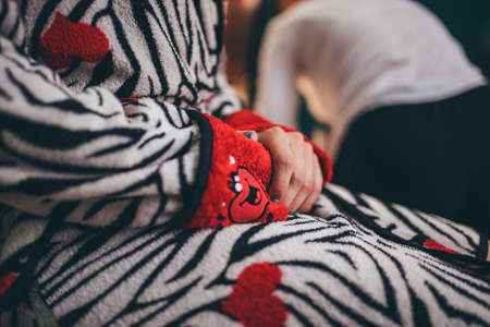 Close up of woman's hands in pajamas with a red heartの写真素材