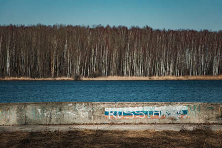 A sign with the name of the city of Ust-Kamenogorsk near the riverの写真素材