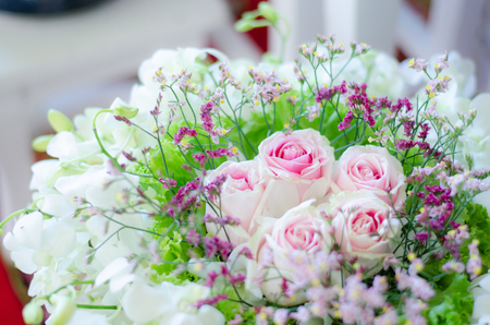 A bouquet of pink roses with pink cactus flowers, surrounded by white orchids.の写真素材